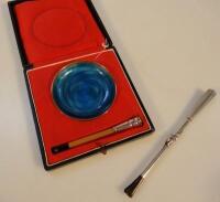 A blue enamelled gilt metal ash tray and two sterling silver cigarette holders.