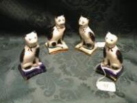 A pair of pottery Staffordshire type seated cats