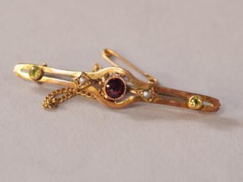 An Edwardian 9ct gold garnet seed pearl and peridot bar brooch.