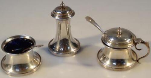 A silver three piece part cruet set