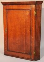 An 18thC oak hanging corner cupboard