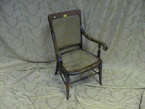 An Edwardian beech open armchair with bergere back and seat