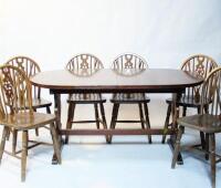 An oak oval drawleaf refectory style dining table and six wheelback chairs.