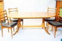 A modern teak extending dining table and six ladderback chairs