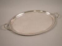 A silver two handled tray with a gadrooned border