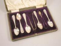 A part set of five silver teaspoons and matching tongs