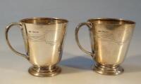 A pair of silver christening mugs