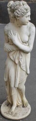 A composite stone freestanding garden statue of a semi clad female