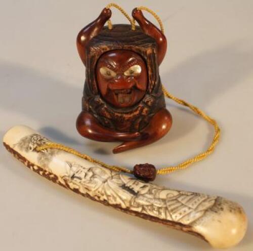 A heavily carved ebonised hardwood and bone netsuke