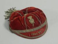 A red velvet and white metal sporting cap