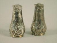 A pair of Edwardian silver Art Nouveau style pepper pots