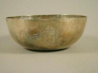 An Edwardian silver bowl with hammered decoration and engraved with a crest