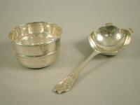 A silver tea strainer and bowl