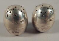 A pair of weighted George V silver egg shaped pepper pots