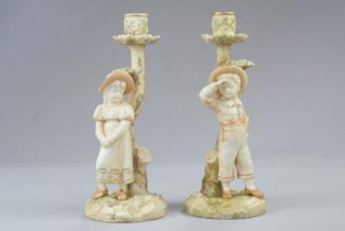 A pair of Royal Worcester Hadley figural candlesticks