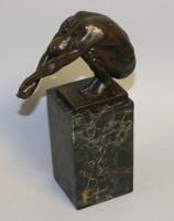 A bronze figure of a naked crouching man