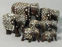 A collection of seven early 20thC Indian hardwood and ivory inlaid elephants