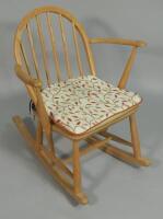 An Ercol type beech stick back child's rocking chair