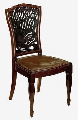 A pair of Art Nouveau mahogany dining chairs with foliate pierced backs and swell legs