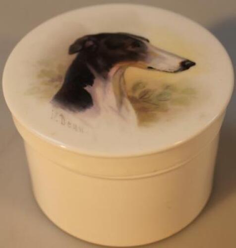 A circular porcelain box and cover painted by James Edwin Dean