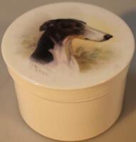 A circular porcelain box and cover painted by James Edwin Dean