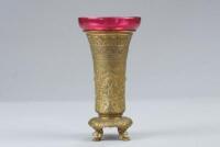 An early 20thC French gilt bronze and cranberry glass vase