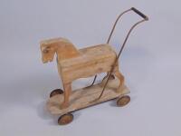 An early 20thC striped pine child's push-a-long horse.