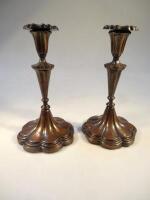 A pair of early 20thC copper candlesticks of floral form