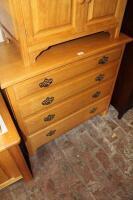 A light oak chest of four long drawers