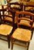 Six stained beech and rush seated ladder back chairs.