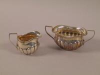 An Edwardian silver two handled sugar bowl and matching milk jug