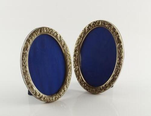 A pair of modern oval silver photograph frames