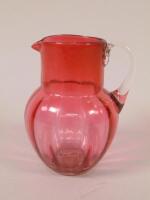 A Victorian cranberry tinted glass jug