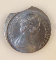 A misshapen and part cut ten pence coin