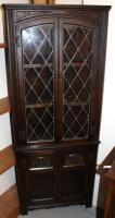 An Old Charm dark oak finish corner cupboard