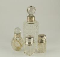 Four small silver collared scent bottles.