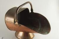 A Victorian copper helmet coal scuttle.