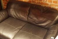 A black leather two seater sofa.