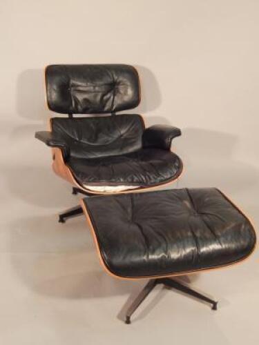 A Charles and Ray Eames design black leather easy chair and stool