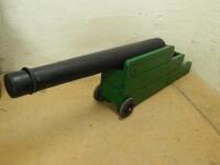 A decorative ebonised and green painted wooden ornamental canon