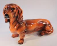 An early 20thC earthenware fireside style model of a dachshund