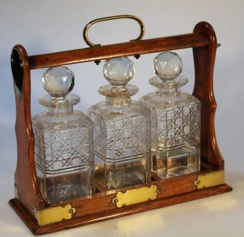 An Edwardian oak three bottle tantalus