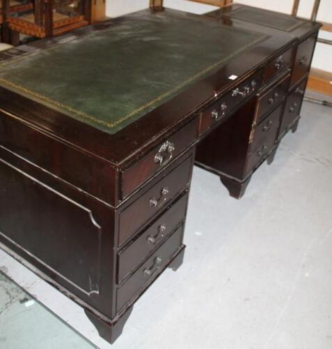 A mahogany finish twin pedestal writing desk