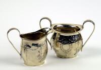 A George V silver cream jug and matching sugar basin