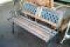 A modern hardwood and cast metal two seater garden bench.