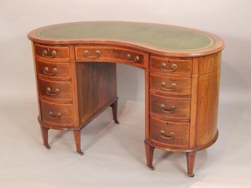 An Edwardian crossbanded mahogany kidney shape kneehole desk