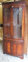 A Georgian style mahogany finish freestanding corner cupboard