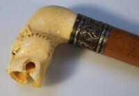 A Chinese ivory topped walnut and white metal walking stick