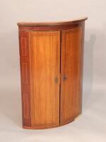 An early 19thC oak and mahogany bow fronted corner cabinet