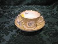 An 18thC porcelain two-handled caudle cup and deep saucer